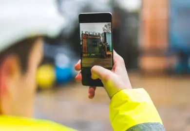 Worker photographing site progress on a mobile phone