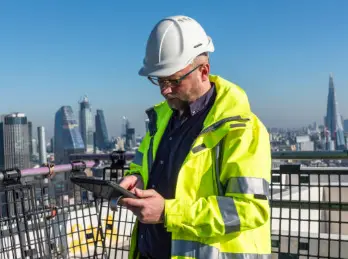 Site inspector reviewing an inspection on a tablet on a rooftop